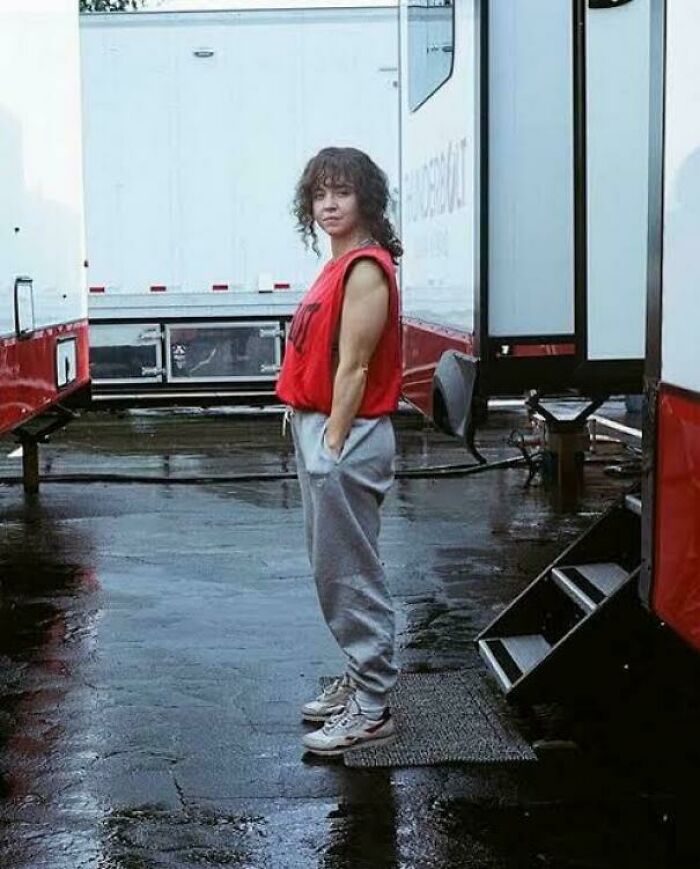 Woman in casual outfit standing near trailers on a wet pavement, illustrating hilariously absurd movie and TV details.
