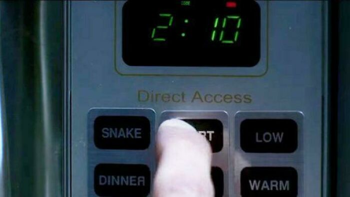 Close-up of a hand pressing the start button on a microwave, illustrating absurd movie and TV details made up yet accurate.