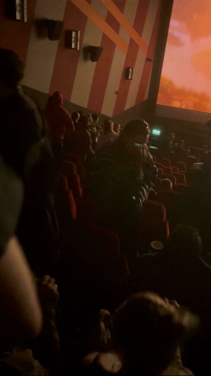 Audience inside a dimly lit movie theater watching a film, highlighting absurd movie and TV details.