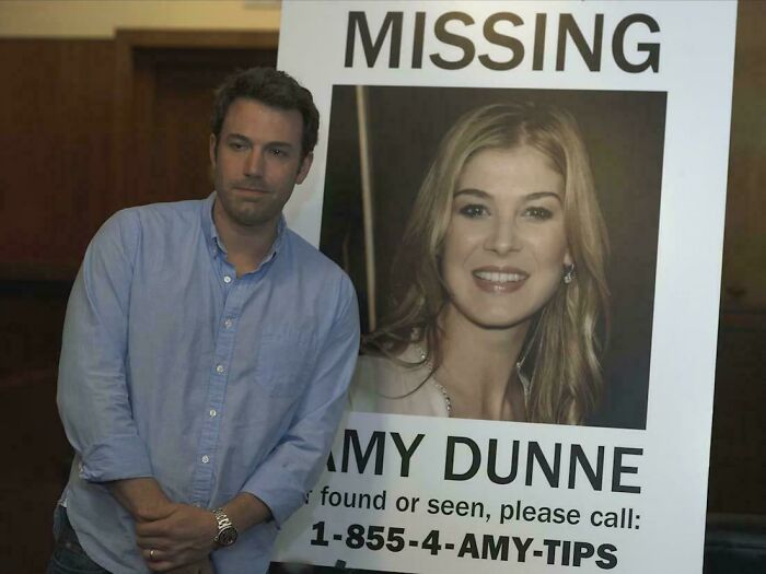 Man standing beside a missing person poster in a scene highlighting absurd movie and TV details humorously portrayed.