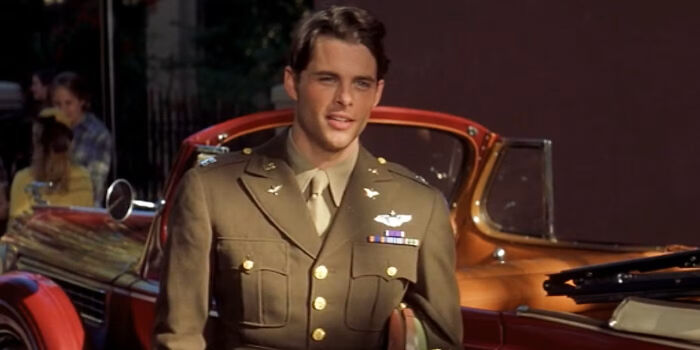Actor in vintage military uniform standing in front of a classic car in a scene with hilariously absurd movie details