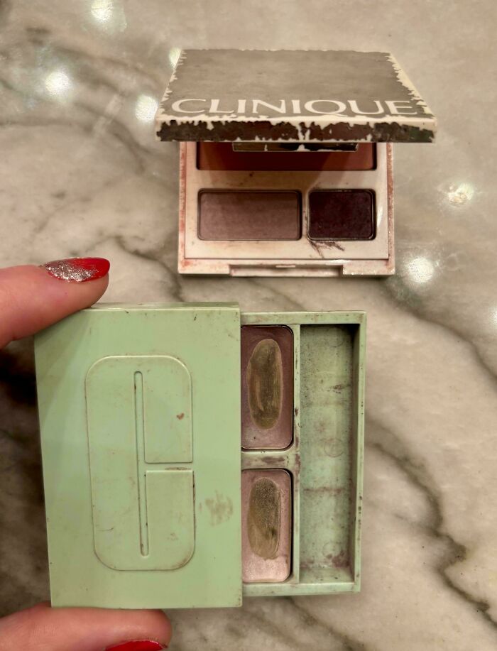 Vintage Clinique makeup palettes held on a marble surface, evoking 90s nostalgia and childhood memories with worn packaging.