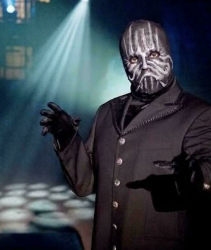 Man in black suit and striped face paint posing dramatically, a funny ’90s meme to jog childhood memories.