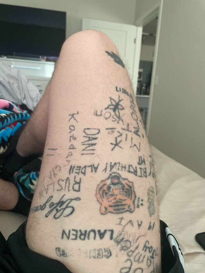 Leg with various bad tattoos including misspelled words and random symbols, showing poor tattoo decisions.