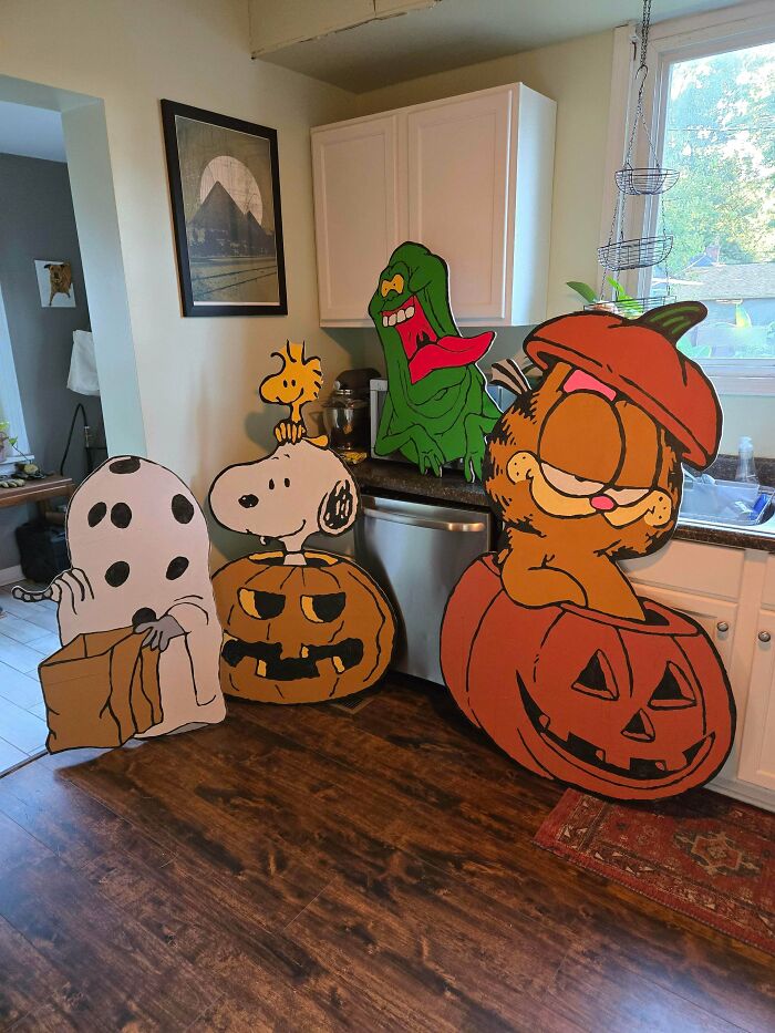 DIY Halloween decorations featuring Snoopy, Garfield, and others with pumpkin designs displayed in a kitchen setting.