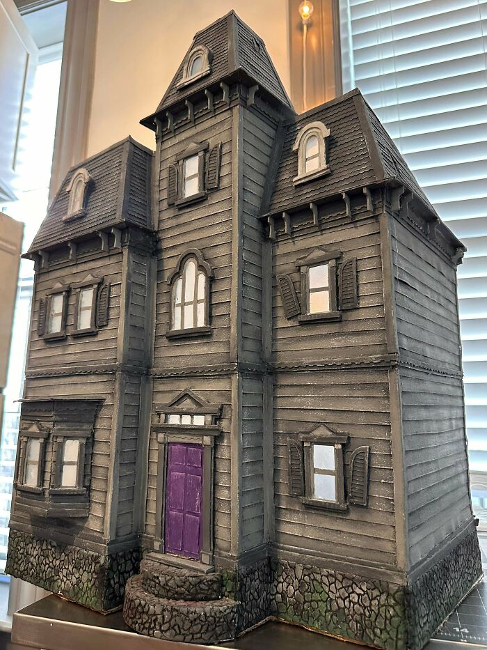 Detailed DIY haunted house model with purple door and stone steps, showcasing impressive craftsmanship and creative wins.