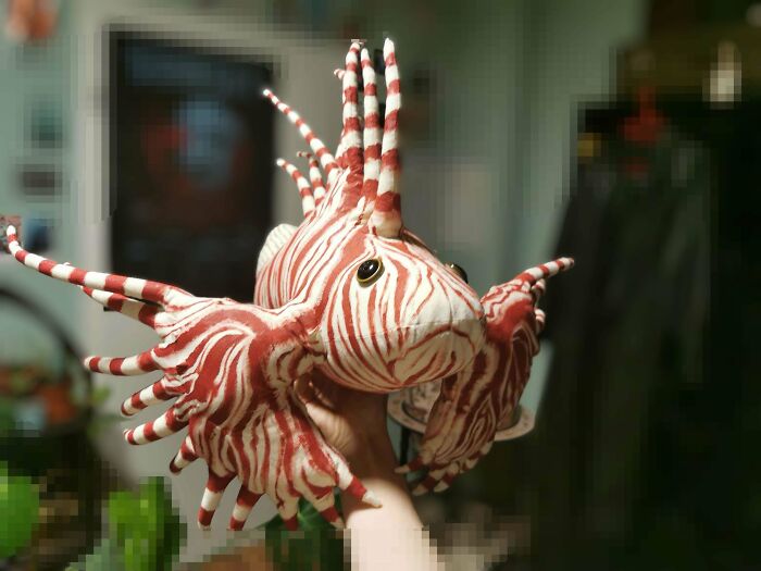 Handcrafted DIY striped fish sculpture held indoors, showcasing creative wins and artistic healing projects.