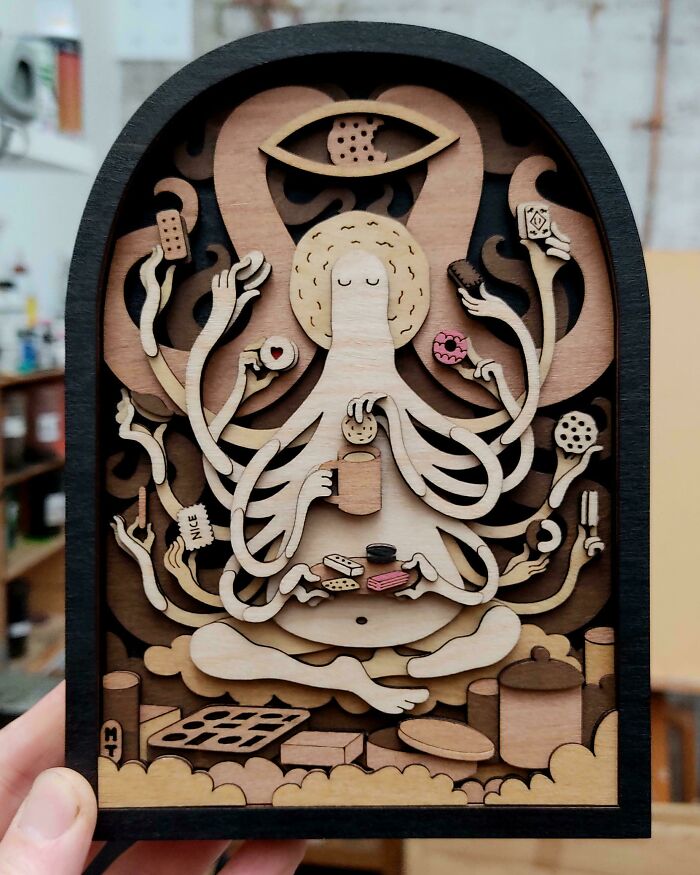 Wooden layered art of an octopus meditating with multiple arms holding DIY snacks and utensils, showcasing creative DIY wins.