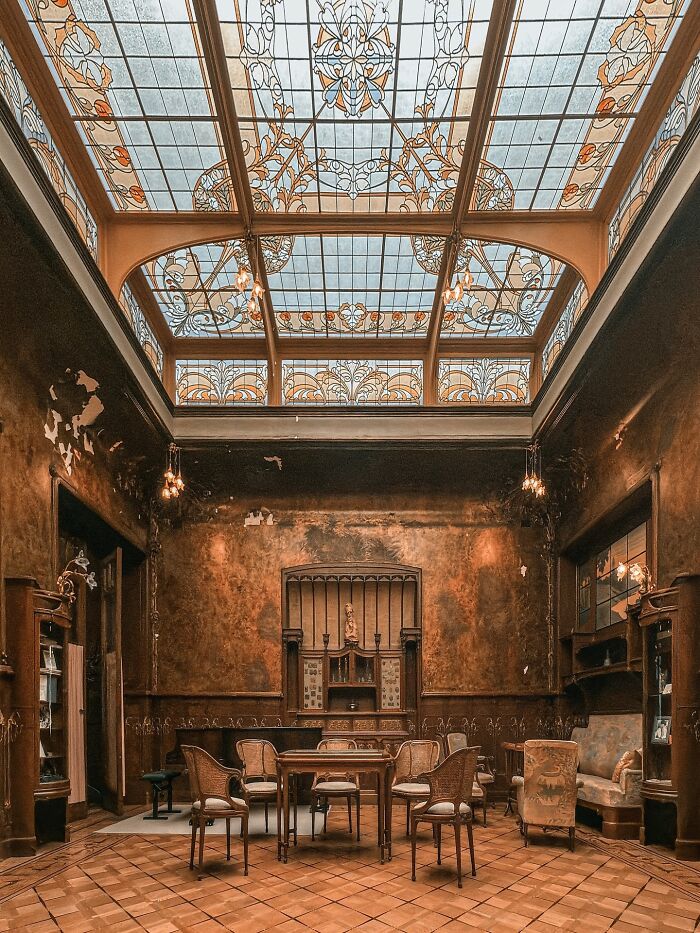 An interior view of a room with a stunning stained-glass ceiling and rich, textured walls, exemplifying beautiful architecture.