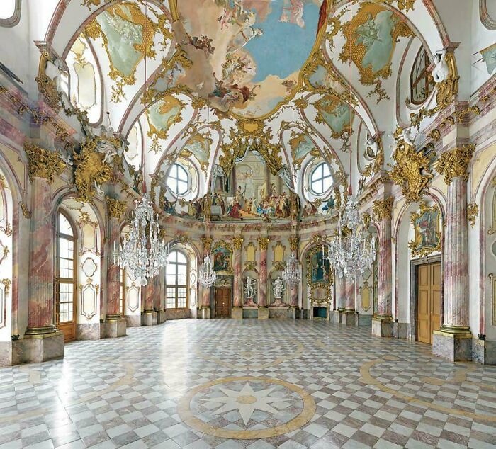 Opulent Baroque hall with frescoes and gold details, an example of beautiful architecture.
