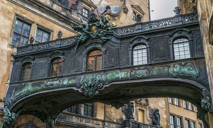 Ornate metal bridge as an example of beautiful architecture connecting two old buildings with decorative elements.