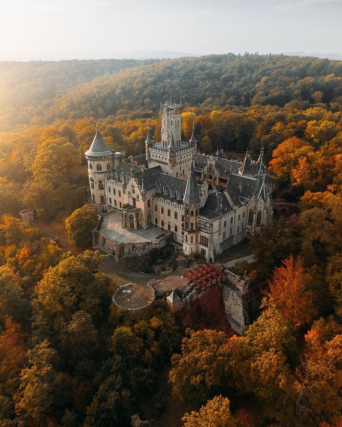 Majestic castle architecture nestled in a forest of autumn colors, displaying stunning and beautiful architecture.