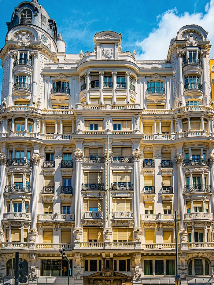 Ornate white building showcasing beautiful architecture with intricate details, balconies, and decorative columns.