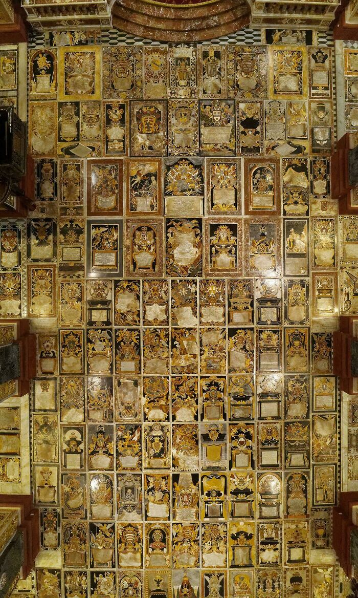 Unreal beautiful architecture featuring a ceiling covered in an array of golden, framed, intricate artworks and designs.
