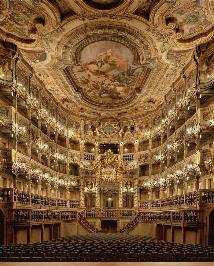 Beautiful architecture of a grand theater with multiple tiers, intricate gold decorations, and a painted ceiling.