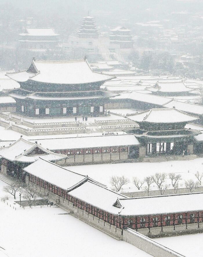 Beautiful architecture: A majestic traditional palace complex covered in snow, creating a serene and picturesque winter scene.