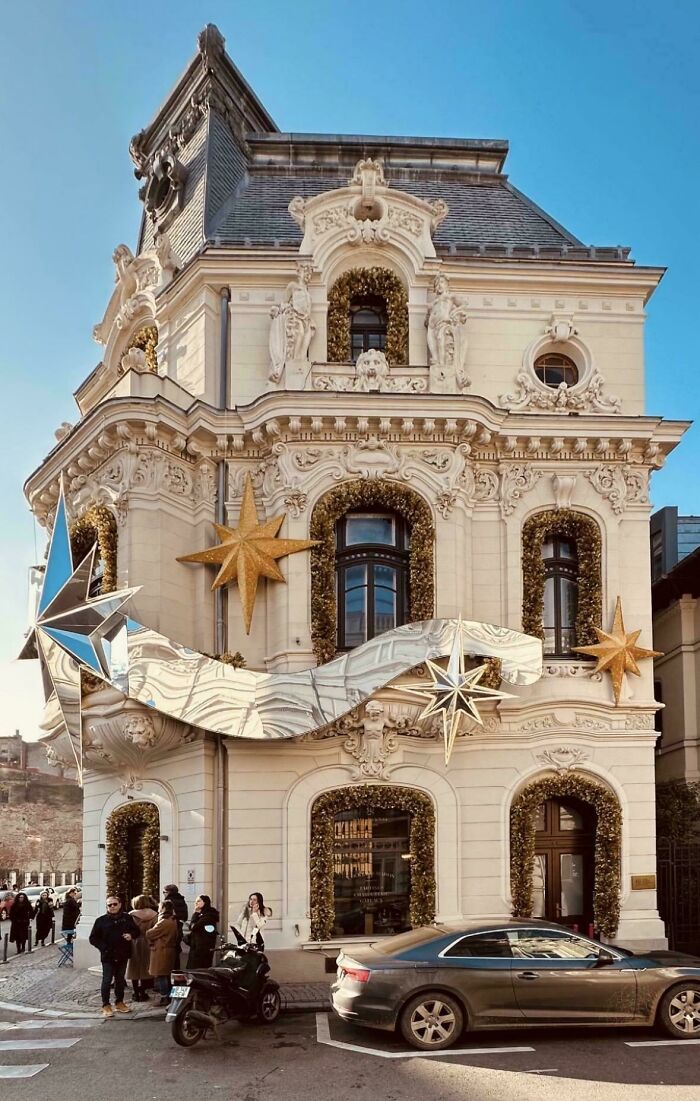 Ornate building facade adorned with large golden stars and garlands, highlighting beautiful architecture.
