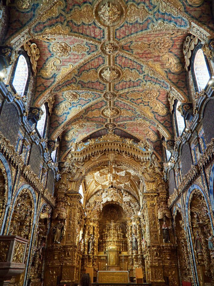 Ornate golden beautiful architecture of a church interior with intricate details on the ceiling and altar, creating an almost unreal grandeur.