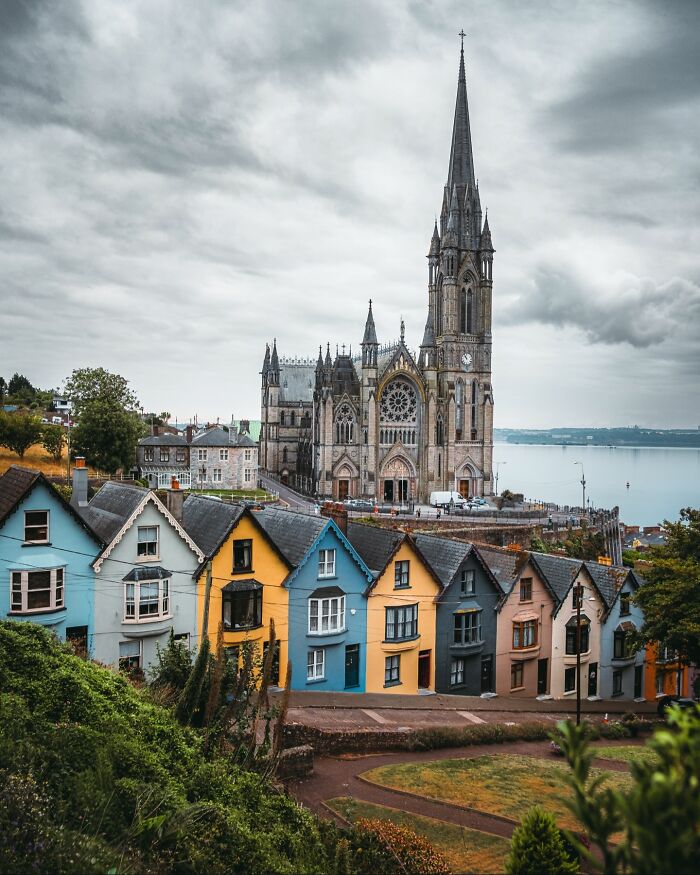 Beautiful architecture: A grand cathedral towering over a row of colorful houses by the water.
