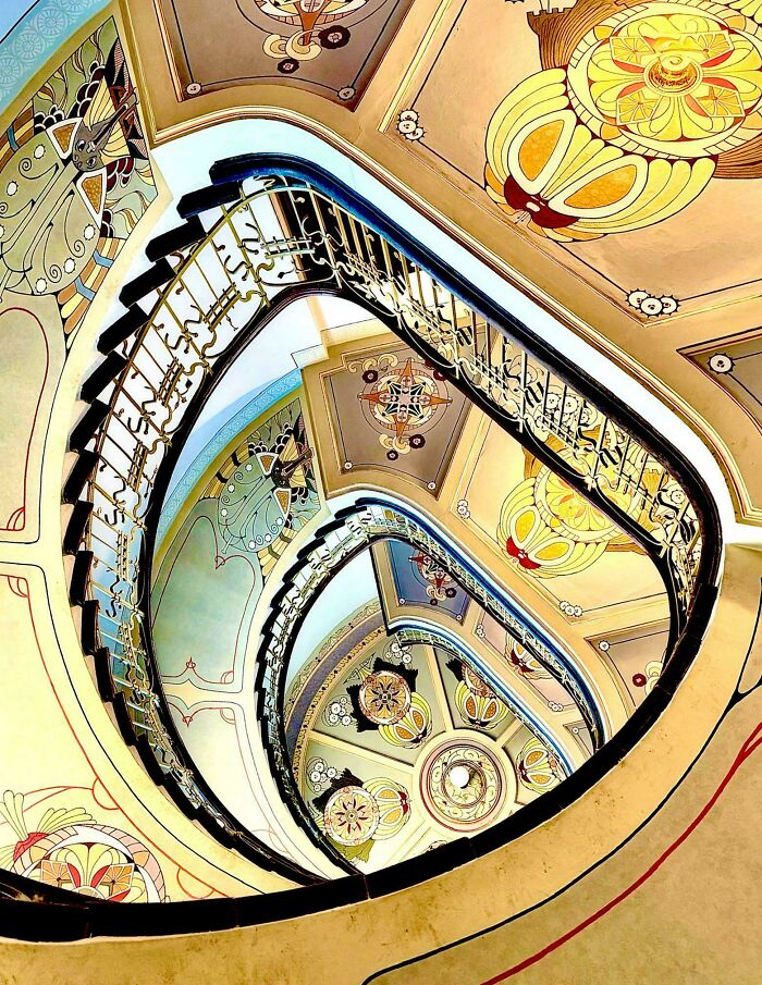 Beautiful architecture: A winding staircase with intricately patterned ceilings and walls.