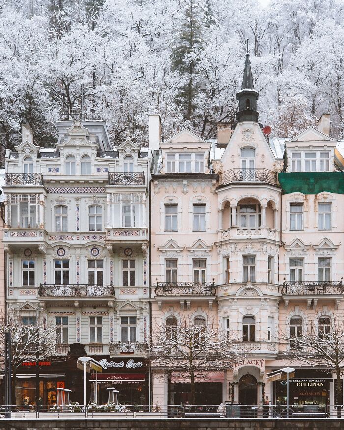 Charming European architecture with ornate balconies and intricate details, covered in a picturesque layer of snow.