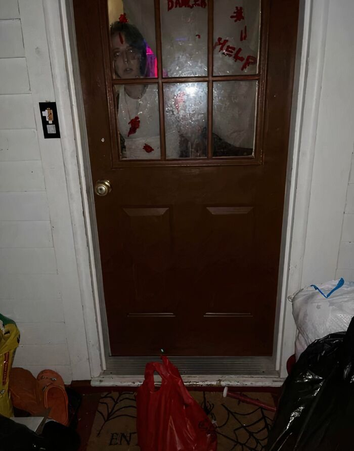 Delivery confirmation pic showing a spooky Halloween prank with a zombie figure behind a door, sent by a delivery driver.