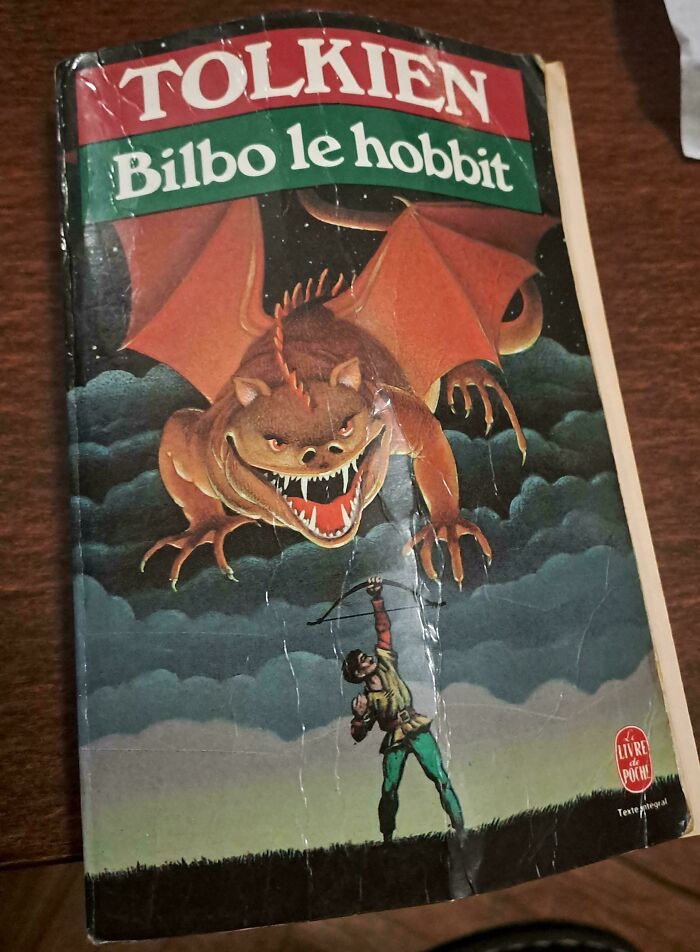 Worn book cover with a poorly designed dragon attacking an archer, showcasing funny awful book covers.