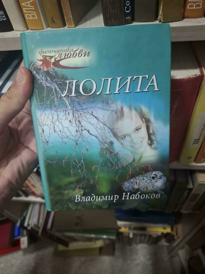 Hand holding a book with an awkwardly edited cover of Lolita, fitting the category of funny awful book covers.