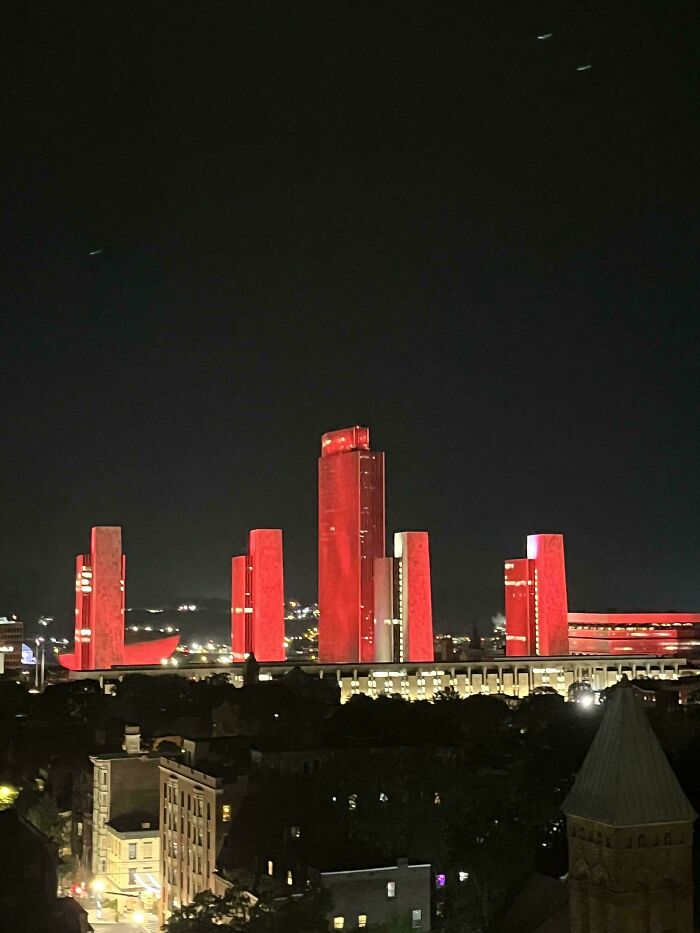 A cityscape at night with several tall, red-illuminated buildings, resembling a lair for an evil mastermind.