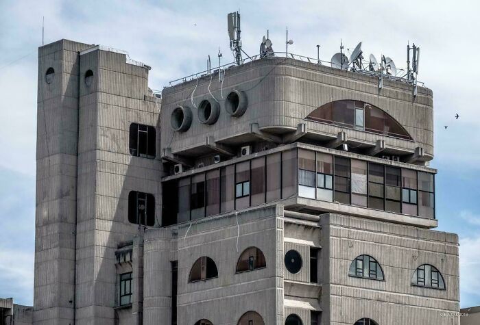 A multi-story building with various antennas and satellite dishes on the roof, perfect for an evil mastermind.