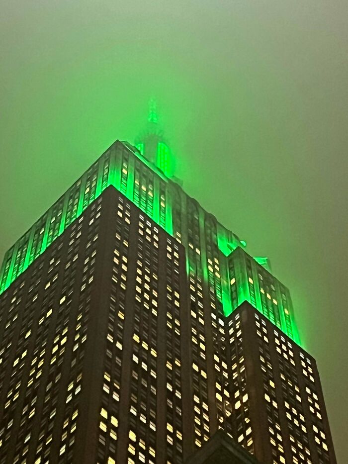 A building with bright green lighting at the top against a foggy sky, looking like it belongs to an evil mastermind.