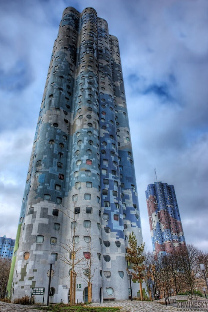 Two tall, uniquely patterned buildings under a cloudy sky, looking like structures an evil mastermind would conquer from.