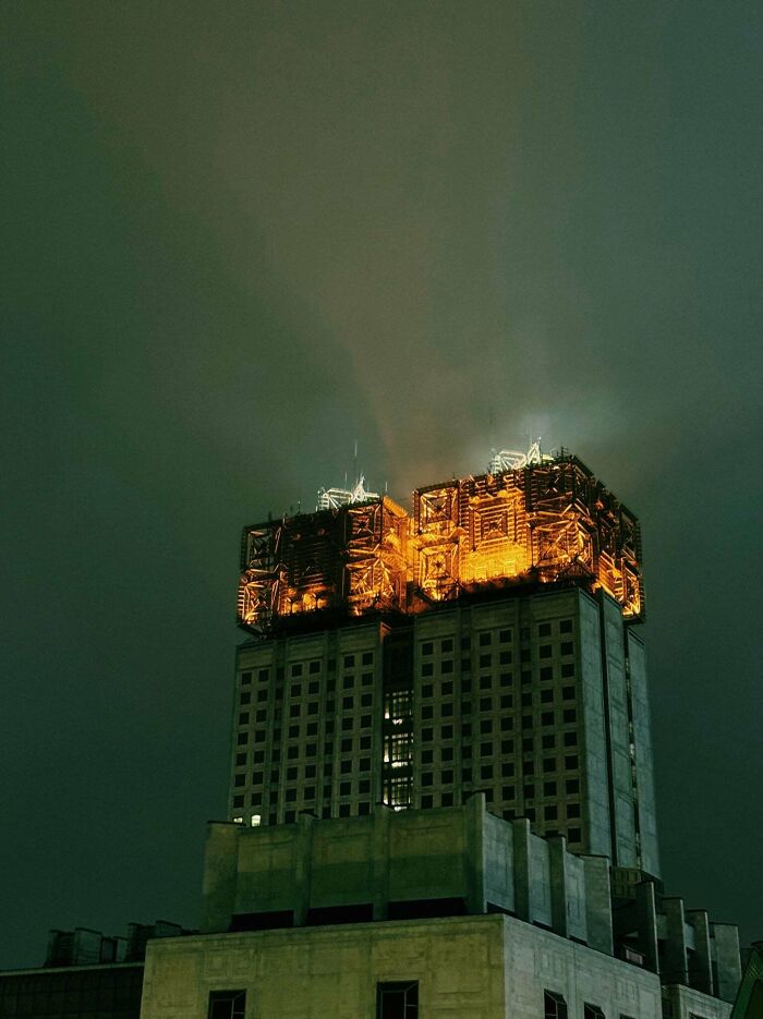 An illuminated, intricate building stands out against a dark sky, suitable for an evil mastermind's headquarters.