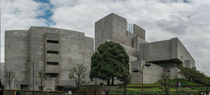 A sprawling brutalist concrete building, which could be a headquarters for an evil mastermind, under a cloudy sky.