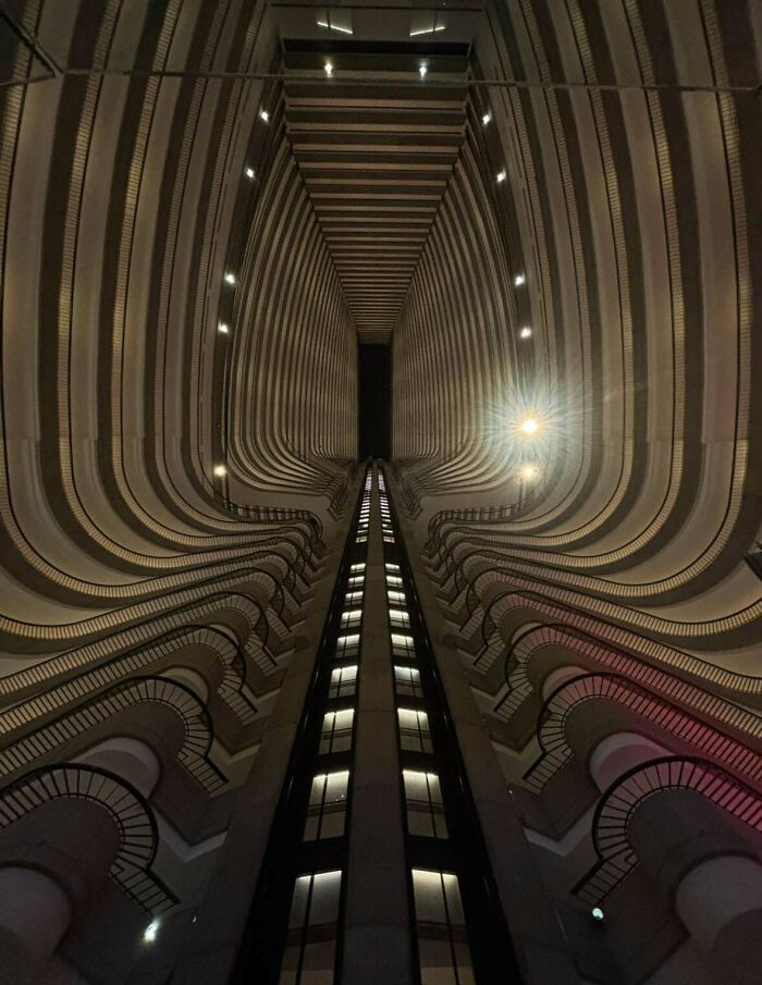 An upward view inside a modern building with curving balconies, a structure an evil mastermind might use.