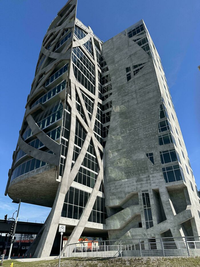 An imposing, concrete evil mastermind building with intricate, geometric patterns and numerous windows, perfect for planning world conquest.