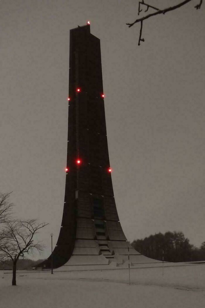 Tall, dark, and ominous building with red lights, designed for an evil mastermind to conquer the world.