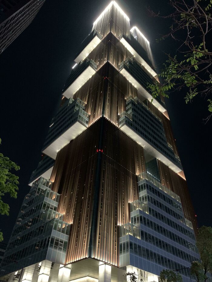A towering, illuminated skyscraper at night, resembling an evil mastermind's building.