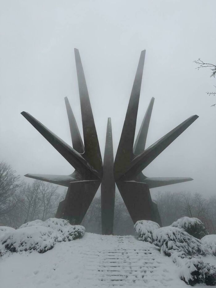 A mysterious, star-shaped monument covered in snow and fog, appearing to be a building for an evil mastermind.