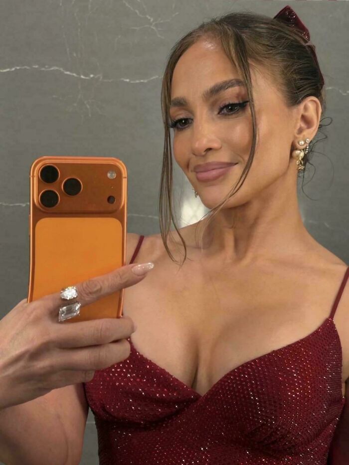 A woman taking a selfie, showcasing a polished look that might not be natural on social media.