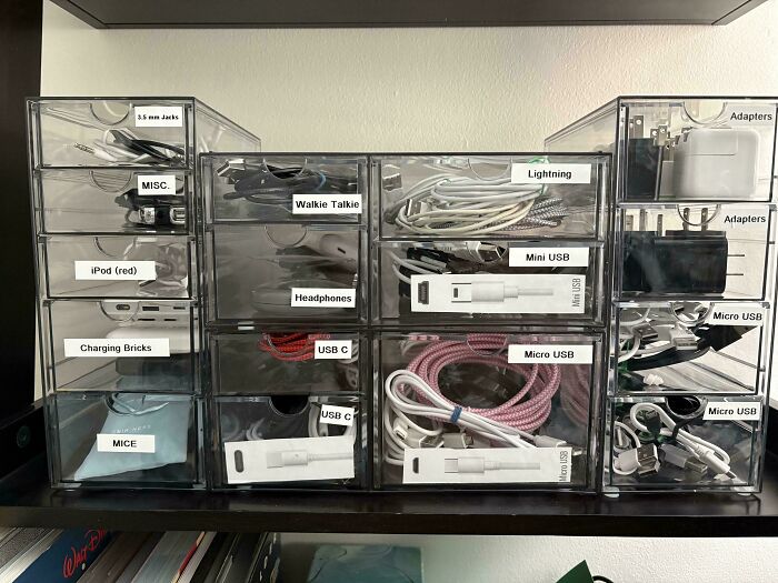 Clear storage drawers neatly organized with various cables and adapters, reflecting a great dad's organized approach.