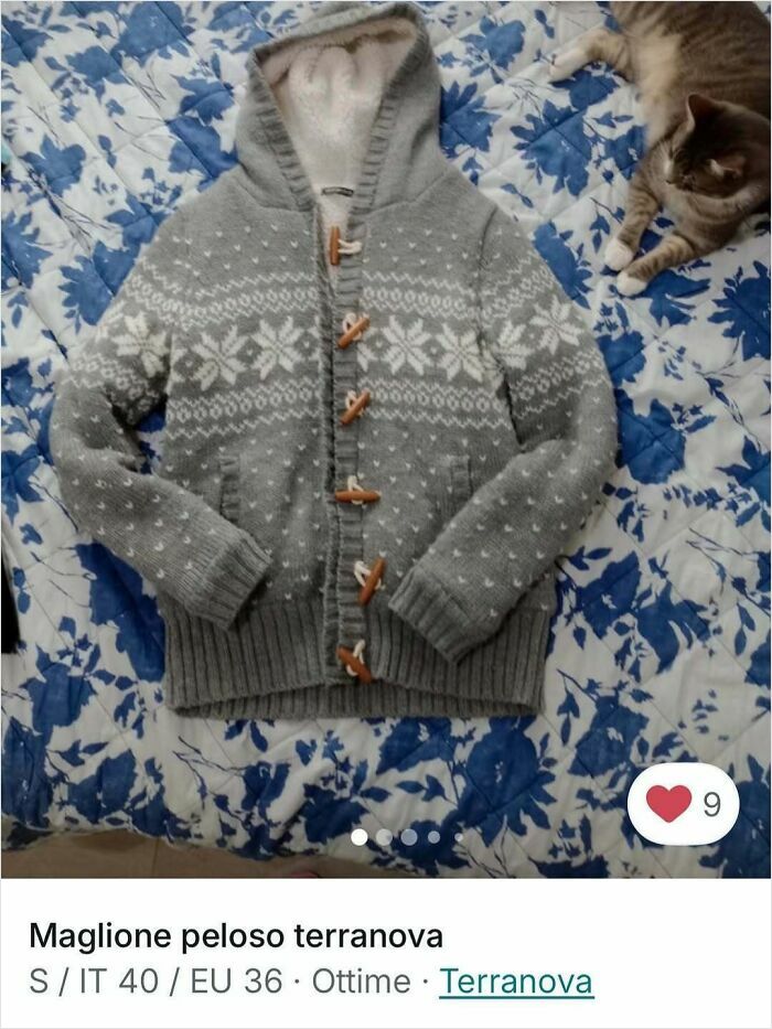 Cozy grey sweater with white snowflake pattern on blue floral bedspread with a cat stealing the spotlight in Vinted ads.