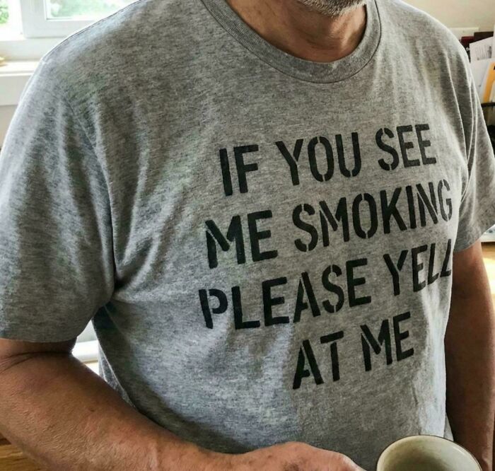 A man wearing a grey T-shirt with the funny, goofy text: If you see me smoking, please yell at me. Summing up being a great dad.