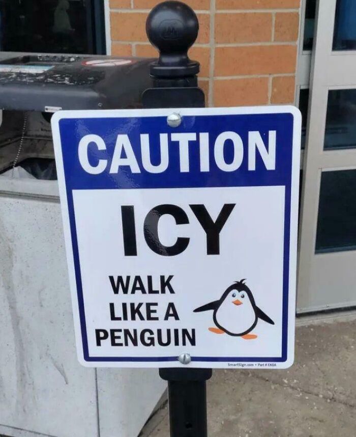 Funny caution sign warning icy walkway with advice to walk like a penguin, a bizarre and hilarious sign example.