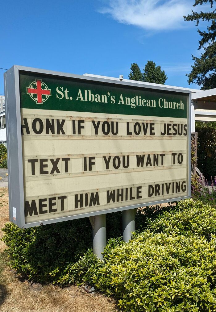 Church sign with bizarre and hilarious message warning against texting while driving seen outdoors on a sunny day.