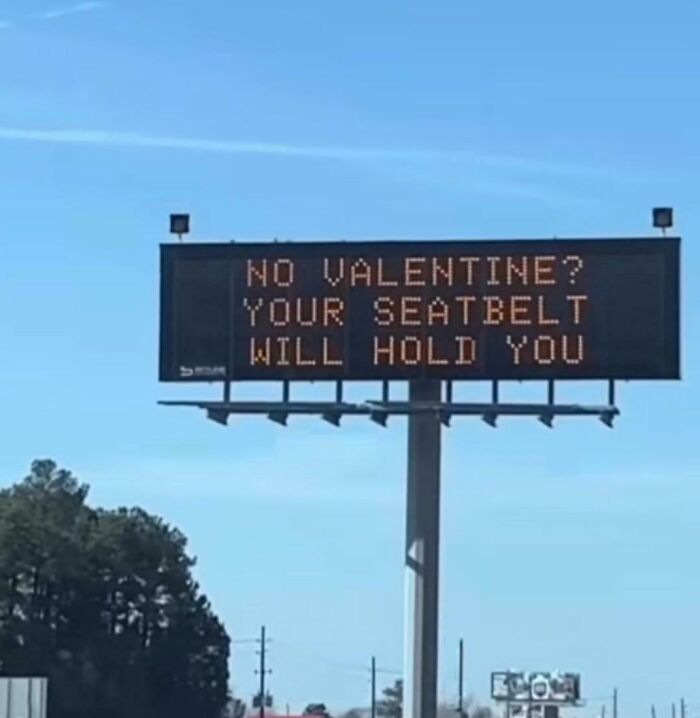 Digital road sign with a bizarre and hilarious message about seatbelts holding you if you have no Valentine.