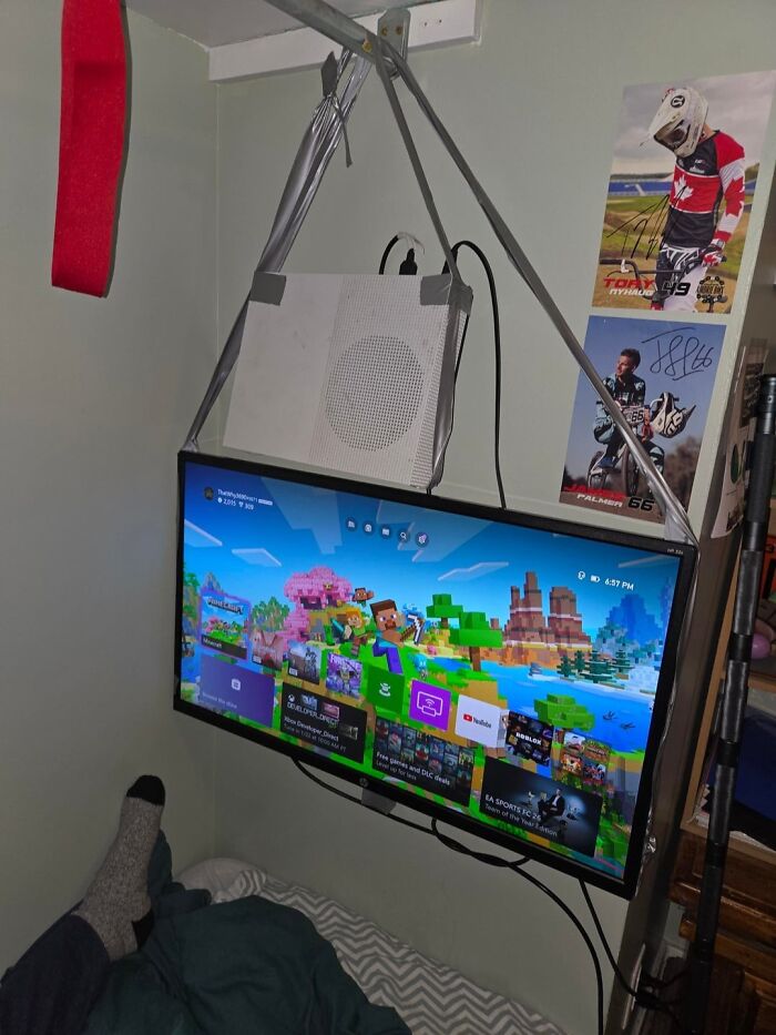 DIY TV setup with speaker suspended by duct tape and straps, an example of if it's stupid but it works.