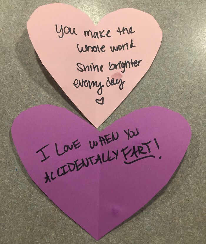 Two heart-shaped notes left by parents with creative and amusing messages written in black ink on colored paper.
