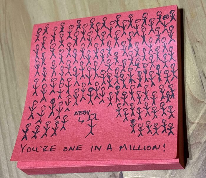 Sticky note with hand-drawn stick figures and a creative and amusing note telling Abby she's one in a million.