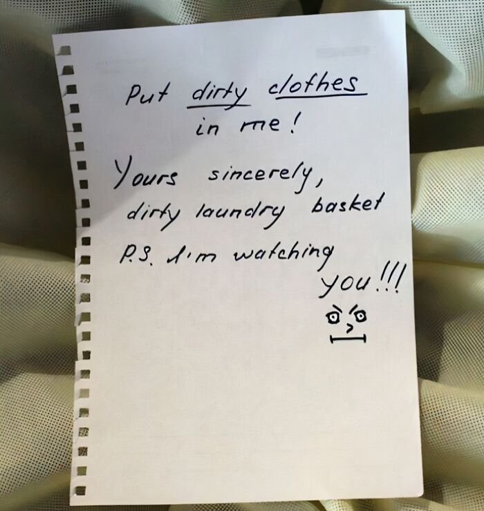 Handwritten creative and amusing note from a laundry basket reminding to put dirty clothes inside with a watching face.
